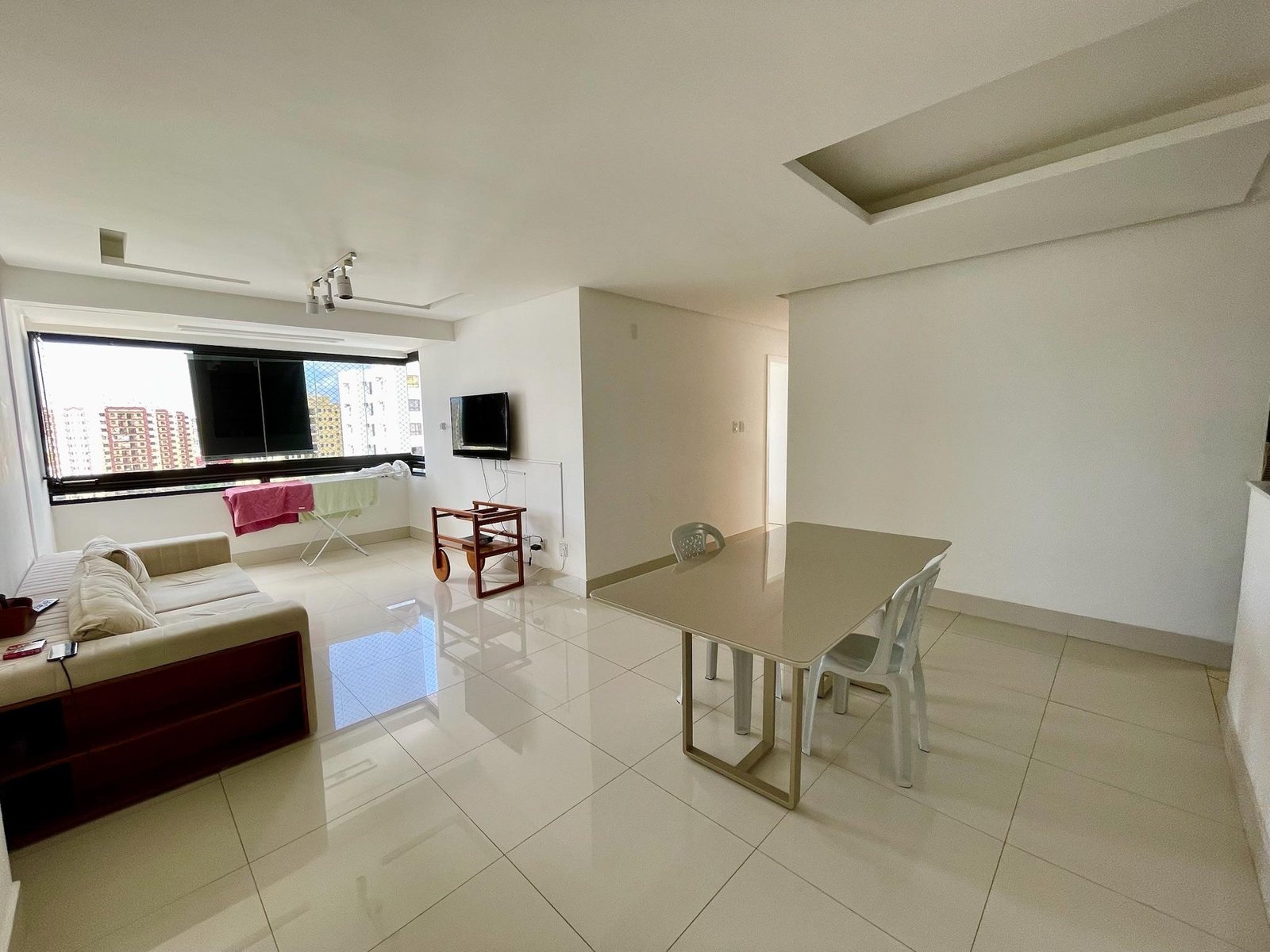 Anúncio do Edifício Iate feito pelo corretor Henrique Lacerda. Foto da sala integrada com varanda.